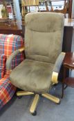 A MODERN BLONDE WOOD REVOLVING ARMCHAIR, COVERED IN BROWN SUEDE, ON WOODEN FIVE SPUR BASE