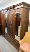 LATE VICTORIAN RED WALNUT MIRRORED TWO DOOR WARDROBE, WITH CENTRAL CARVED PANEL, BELOW A DENTIL