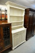 A PINE WHITE PAINTED DRESSER, HAVING TWO DRAWERS ABOVE TWO CUPBOARD DOORS WITH PLATE RACK ABOVE