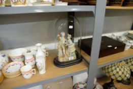 A BISQUE GROUP FIGURE OF A BOY AND GIRL DISPLAYED IN AN OVAL GLASS DOME