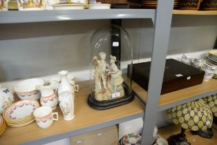 A BISQUE GROUP FIGURE OF A BOY AND GIRL DISPLAYED IN AN OVAL GLASS DOME