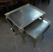 A NEST OF THREE SILVERED METAL COFFEE TABLES