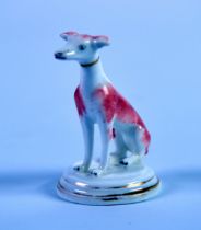 MID NINETEENTH CENTURY ENGLISH PORCLEAIN MODEL OF A SEATED DOG, with brown splashed and gilt collar,