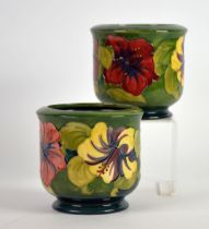 MOORCROFT: PAIR OF GEORGE V MOORCROFT POTTERY HIBISCUS PATTERN CACHE POTS, each 5in (12.5cm) (2)