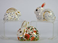 ROYAL CROWN DERBY: THREE PAPERWEIGHTS modelled as rabbits, including a Collector's