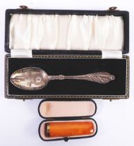 AMBER CIGAR HOLDER with gold plated mount, in case and an ELECTROPLATED PATENT CHRISTENING SPOON,