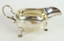 GEORGE V SILVER SAUCE BOAT BY MAPPIN & WEBB, of typical form with high scroll handle, cyma border