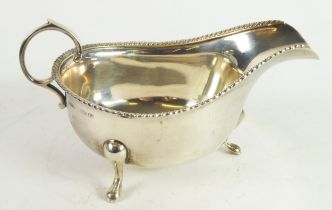 GEORGE VI SILVER SAUCE BOAT, of typical form with flying scroll handle, gadrooned border and pad