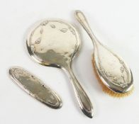 LADY’S SILVER CLAD DRESSING TABLE HAND MIRROR AND MATCHING HAIRBRUSH, embossed with floral swags,