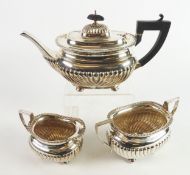 EARLY TWENTIETH CENTURY SILVER THREE PIECE TEASET, of part fluted, rounded oblong form with