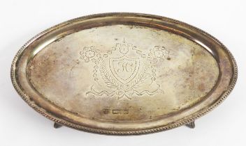 ANTIQUE SILVER CARD TRAY, of oval form with beaded border and reeded tab feet, the centre engraved