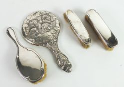 FOUR PIECES OF SILVER CLAD DRESSING TABLE WARES, comprising: HAND MIRROR, embossed with cherubic