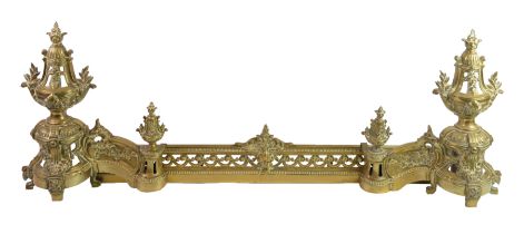 NINETEENTH CENTURY PIERCED BRASS ADJUSTABLE FENDER, with floral capped front and pedestal urn