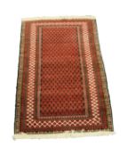 BELUCH, PERSIAN RUG with all-over compact crimson pattern on a black field, multiple border stripes,