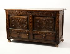 ANTIQUE CARVED OAK MULE CHEST, the moulded two plank top above a two panelled front, ornately carved