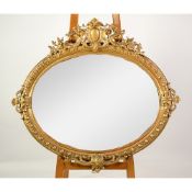 ROCOCO WALL MIRROR: A good Victorian gilt-framed oval cameo wall mirror, the classical rococo
