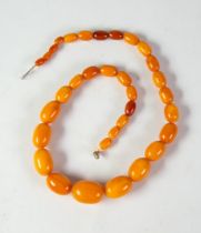 NECKLACE OF GRADUATED OVAL BUTTERSCOTCH AMBER BEADS, 17 1/4in (44cm) long
