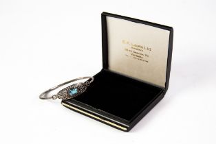 SILVER SPRUNG BANGLE, the oval top scroll pierced and set with an oval blue topaz, 925 mark