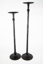 GRADUATED PAIR OFMODERN BLACK METAL FLOOR STANDING CANDLE HOLDERS, each with slender, knopped