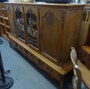 CONTINENTAL OAK FOUR DOOR SIDE CABINET, THE UPPER ELEVATED WITH TWO CENTRAL GLAZED DOORS, GLAZED