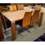 A STYLISH WOODEN VENEER AND BRUSHED STEEL EXTENDING DINING TABLE, HAVING FOLD-AWAY LEAF BELOW,