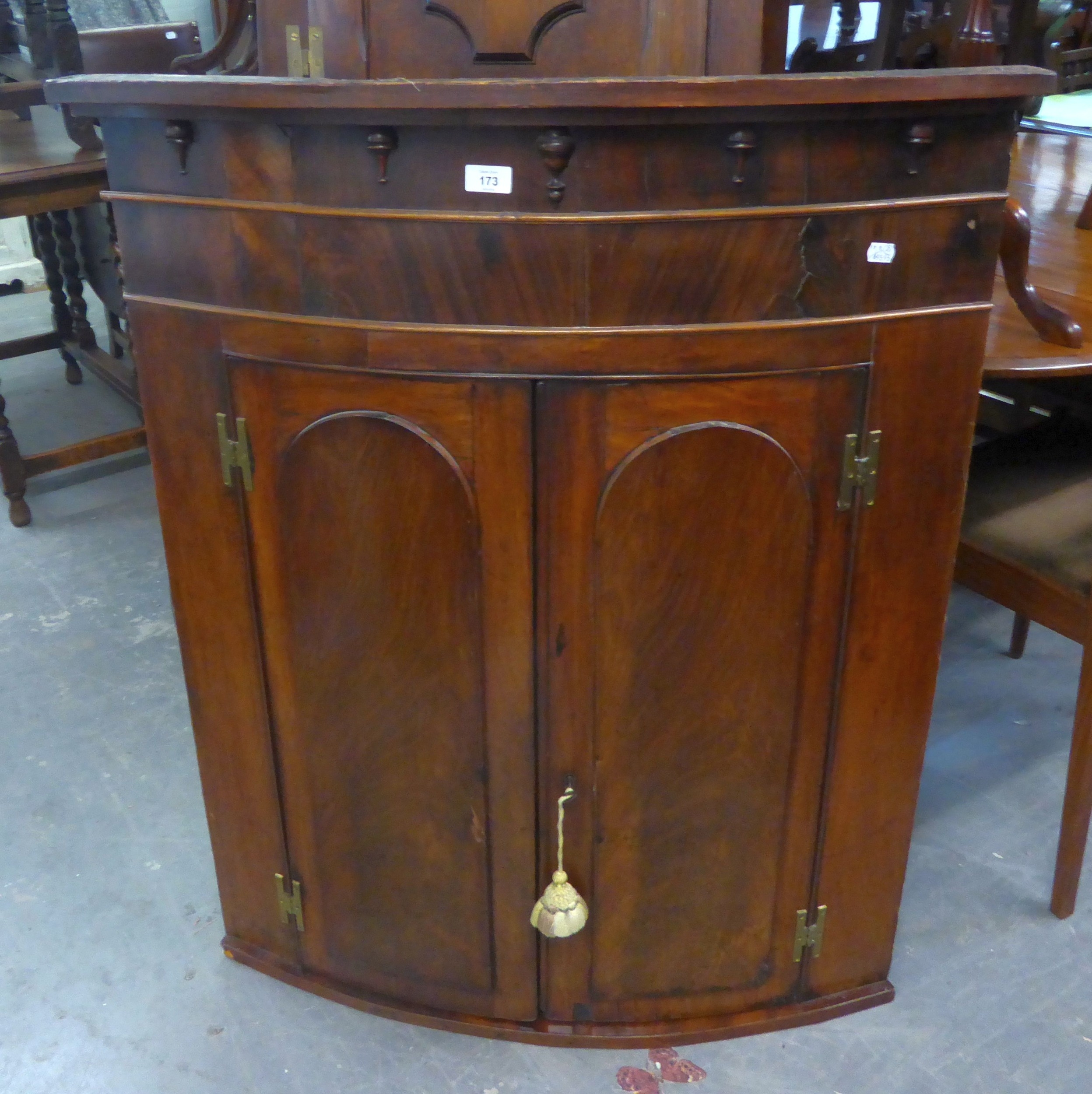 A GEORGE III MAHOGANY BOW-FRONT CORNER CUPBOARD