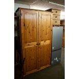 A PINE TWO DOOR WARDROBE, SHELF AND HANGING RAIL AND A SIMILAR PINE 3 DRAWER BEDSIDE CABINET (2)