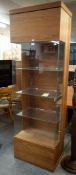 A STYLISH TALL WALNUT VENEER AND GLASS DISPLAY CABINET, HAVING FOUR GLASS FITTED SHELVES AND LIGHTS,