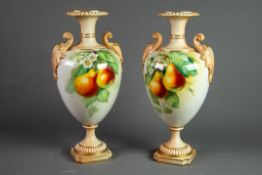PAIR OF EARLY TWENTIETH CENTURY ROYAL WORCESTER HAND PAINTED TWO HANDLED PEDESTAL CHINA VASES SIGNED