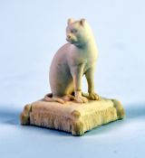 NINETEENTH CENTURY ROCKINGHAM BISCUIT PORCELIAN MODEL OF A SEATED CAT, on an oblong tassled