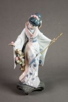 LLADRO ‘TERUKO’ PORCELAIN FIGURE OF A GEISHA, modelled holding a folded parasol and picking flowers,