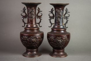 PAIR OF TWENTIETH CENTURY JAPANESE TWO HANDLED PEDESTAL PATINATED BRONZE VASES, each of baluster