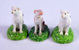 THREE NINETEENTH CENTURY STAFFORDSHIRE PORCELAIN MODELS OF SEATED DOGS, including a PAIR WITH