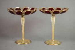 PAIR OF BOHEMIAN RUBY OVERLAID AND GILT ETCHED PETAL PATTERN CIRCULAR DISHES, on tall tapering