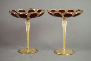 PAIR OF BOHEMIAN RUBY OVERLAID AND GILT ETCHED PETAL PATTERN CIRCULAR DISHES, on tall tapering