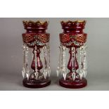 PAIR OF RUBY GLASS TABLE LUSTRES, each of typical form with wavy rims and prism cut glass drops,