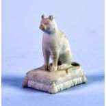 NINETEENTH CENTURY ROCKINGHAM BISCUIT PORCELAIN MODEL OF A SEATED CAT, on an oblong tasselled