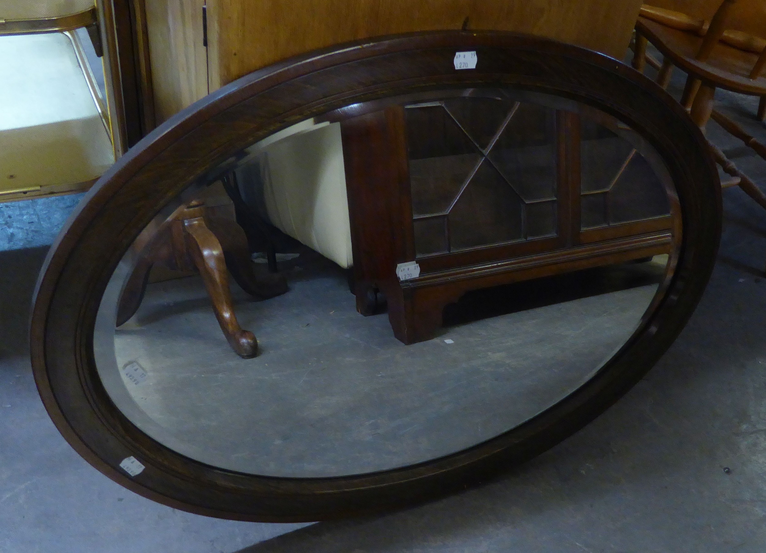 A MAHOGANY OVAL SHAPED BEVELLED EDGE WALL MIRROR IN CROSSBANDED FRAME AND A MAHOGANY CIRCULAR