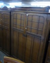 PANELLED OAK BEDROOM SUITE, COMPRISING LADY’S AND GENTS WARDROBES, PEDESTAL DRESSING TABLE WITH