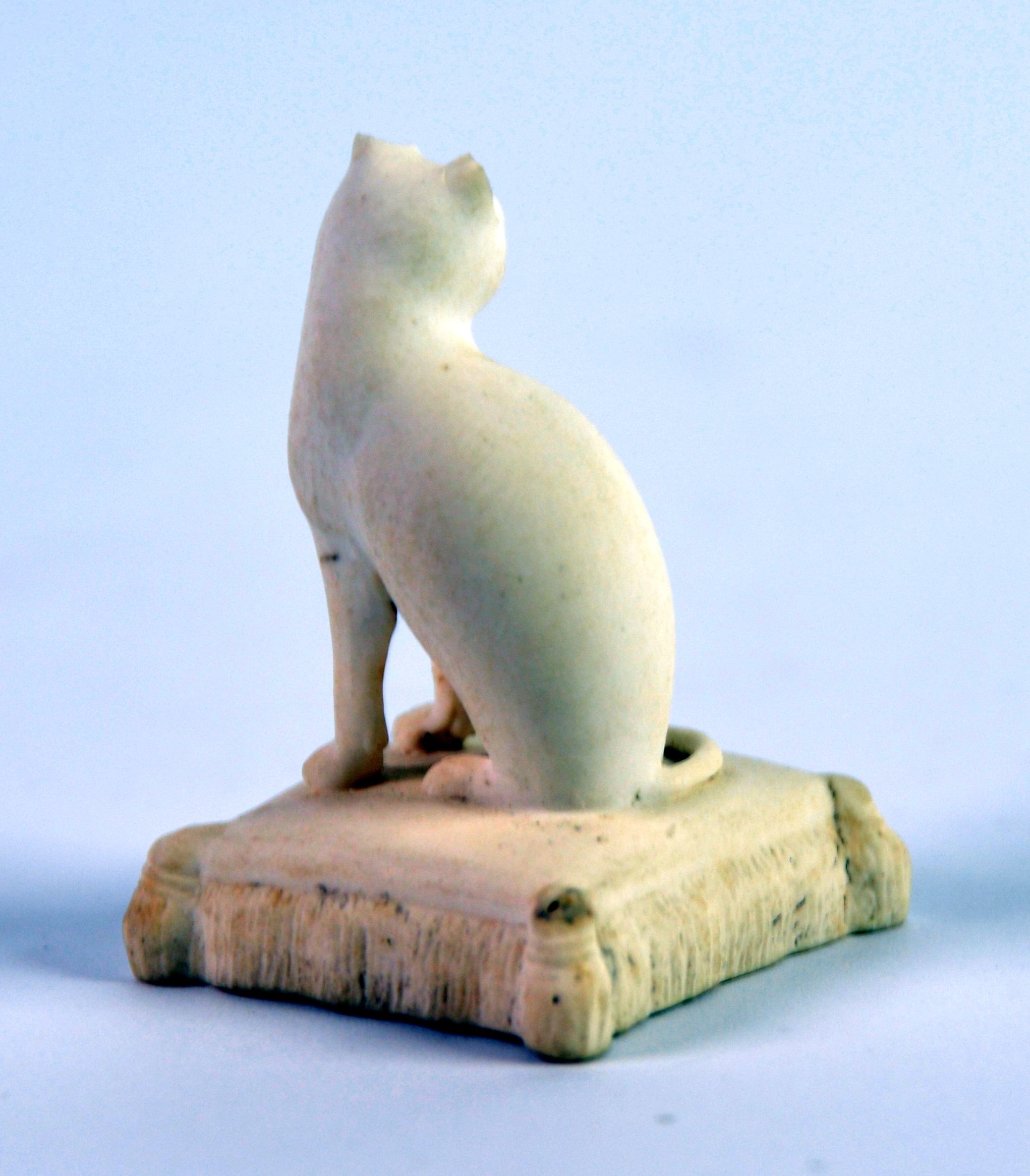 NINETEENTH CENTURY ROCKINGHAM BISCUIT PORCELAIN MODEL OF A SEATED CAT, on an oblong tasselled - Image 2 of 2