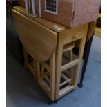 A PINE MODERN CIRCULAR FALL-LEAF KITCHEN TABLE, WITH TWO NESTING STOOL UNDERNEATH