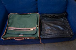 A GREEN CANVAS AND LEATHER MOUNTED SUITCASE, 22” WIDE AND A GENT’S BLACK LEATHER FOLD-OVER SUIT