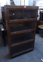 AN OAK FOUR-TIER GLOBE WERNICKE SECTIONAL BOOKCASE WITH GLAZED LIFT-UP FRONTS