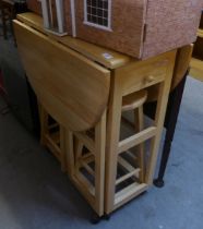 A PINE MODERN CIRCULAR FALL-LEAF KITCHEN TABLE, WITH TWO NESTING STOOL UNDERNEATH