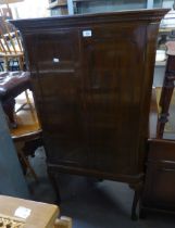 A MAHOGANY FLOOR STANDING CORNER CUPBOARD, HAVING TWO PANEL DOORS, RAISED ON LONG SLENDER CABRIOLE