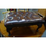 A CHESTERFIELD FOOTSTOOL, COVERED IN BROWN LEATHER AND RAISED ON SMALL CABRIOLE LEGS