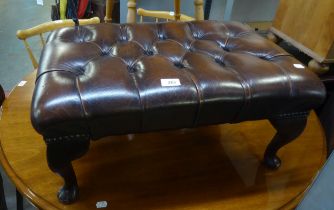 A CHESTERFIELD FOOTSTOOL, COVERED IN BROWN LEATHER AND RAISED ON SMALL CABRIOLE LEGS