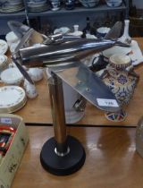 A BRIGHT METAL MODEL AEROPLANE, ON STAND