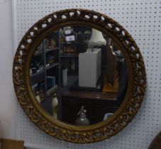 A CIRCULAR WALL MIRROR IN PIERCED GILT FRAME