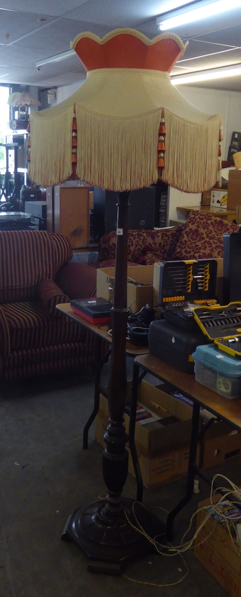 A MAHOGANY STANDARD LAMP, ON CIRCULAR BASE AND THE SILK SHADE WITH DEEP FRINGE